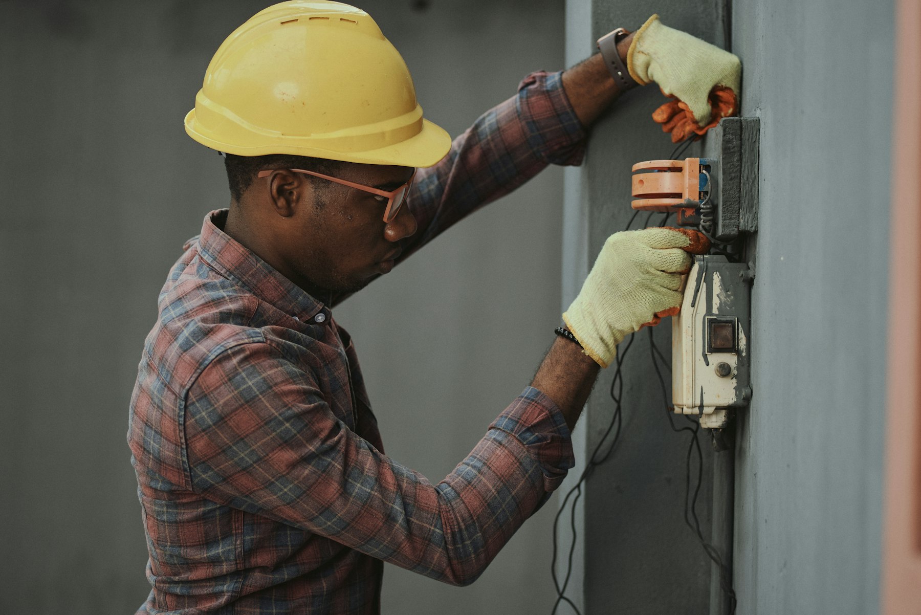 Technician servicing building equipment on an MDU riser